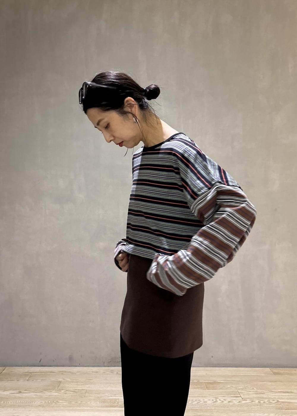 ブラック系のスラックス、ブラウン系のスカート、ブラック系のTシャツ/カットソーを着用したレディースの秋コーディネートの8枚目の写真