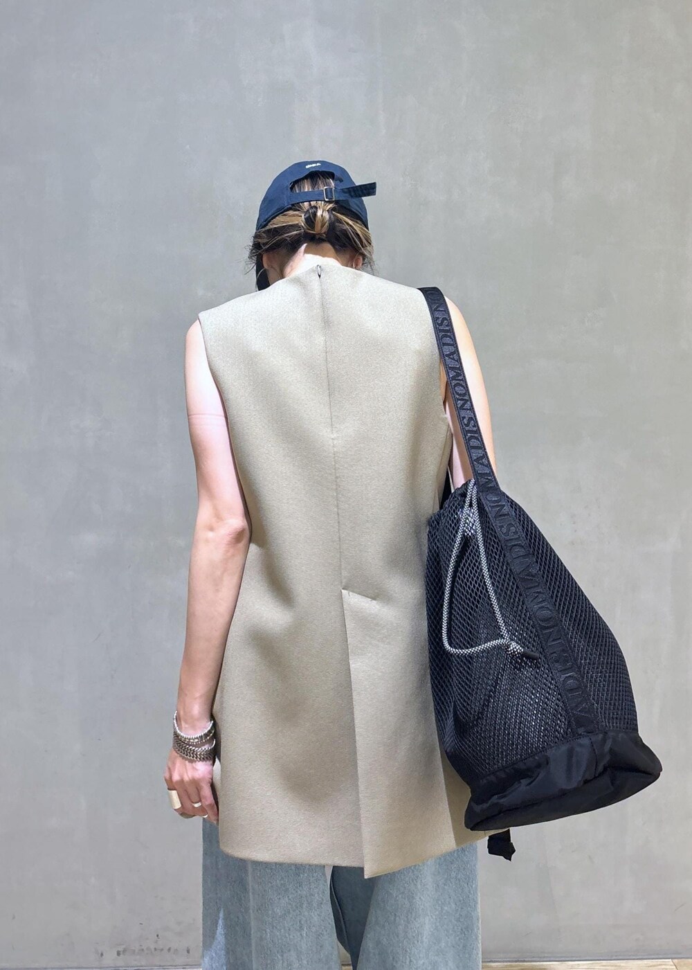 ベージュ系のベスト、ブラック系のスニーカー、ブラック系のショルダーバッグを着用したレディースの夏コーディネートの10枚目の写真