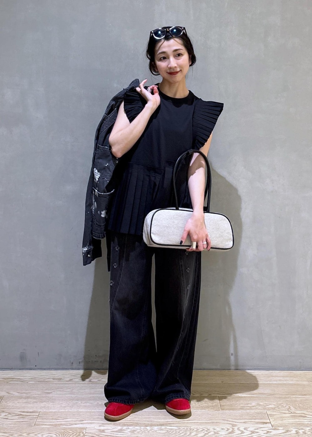 ブラック系のTシャツ/カットソー、ブラック系のデニムパンツ、ホワイト系のボストンバッグを着用したレディースの春コーディネートの2枚目の写真