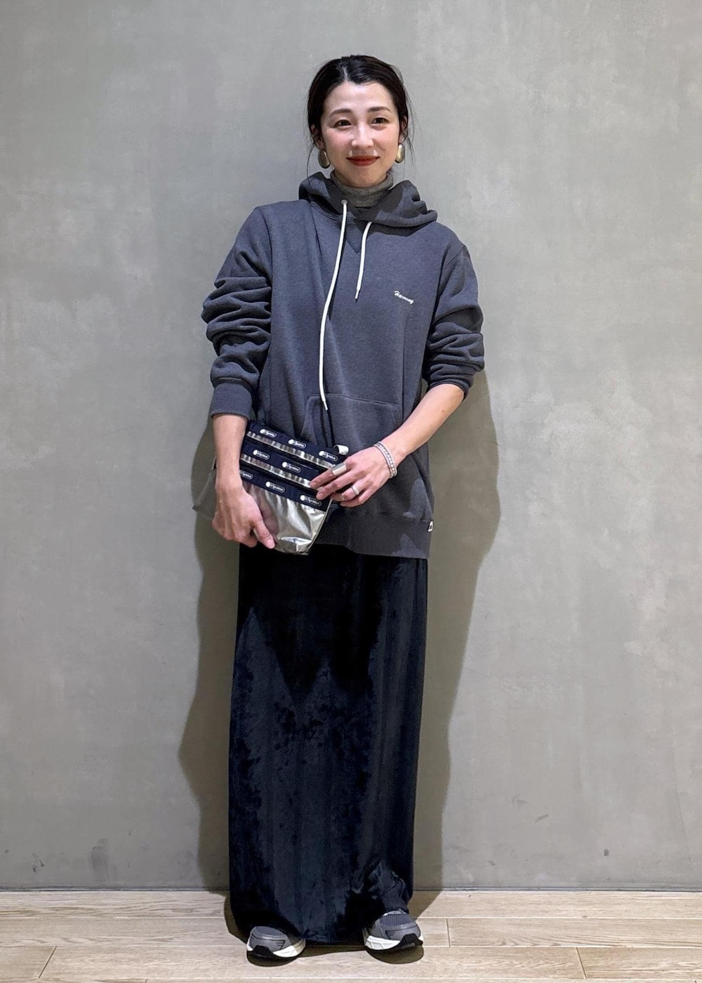 グレー系のスニーカー、ブラック系のスカート、グレー系のパーカーを着用したレディースの冬コーディネートの5枚目の写真