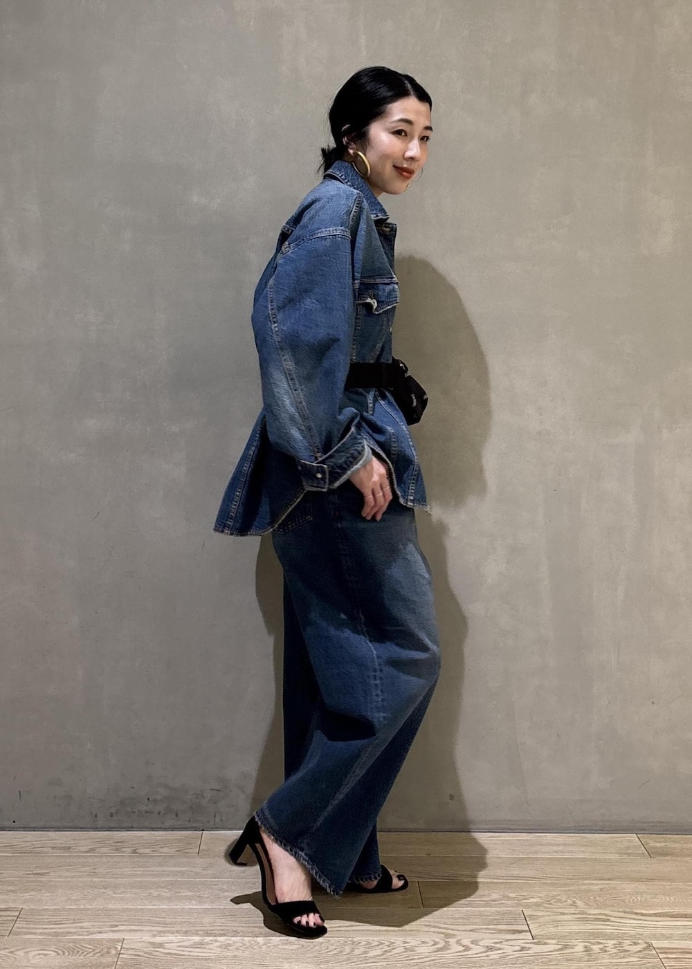 ブルー系のデニムジャケット、ブルー系のデニムパンツ、ブラック系のトートバッグを着用したレディースの春コーディネートの4枚目の写真