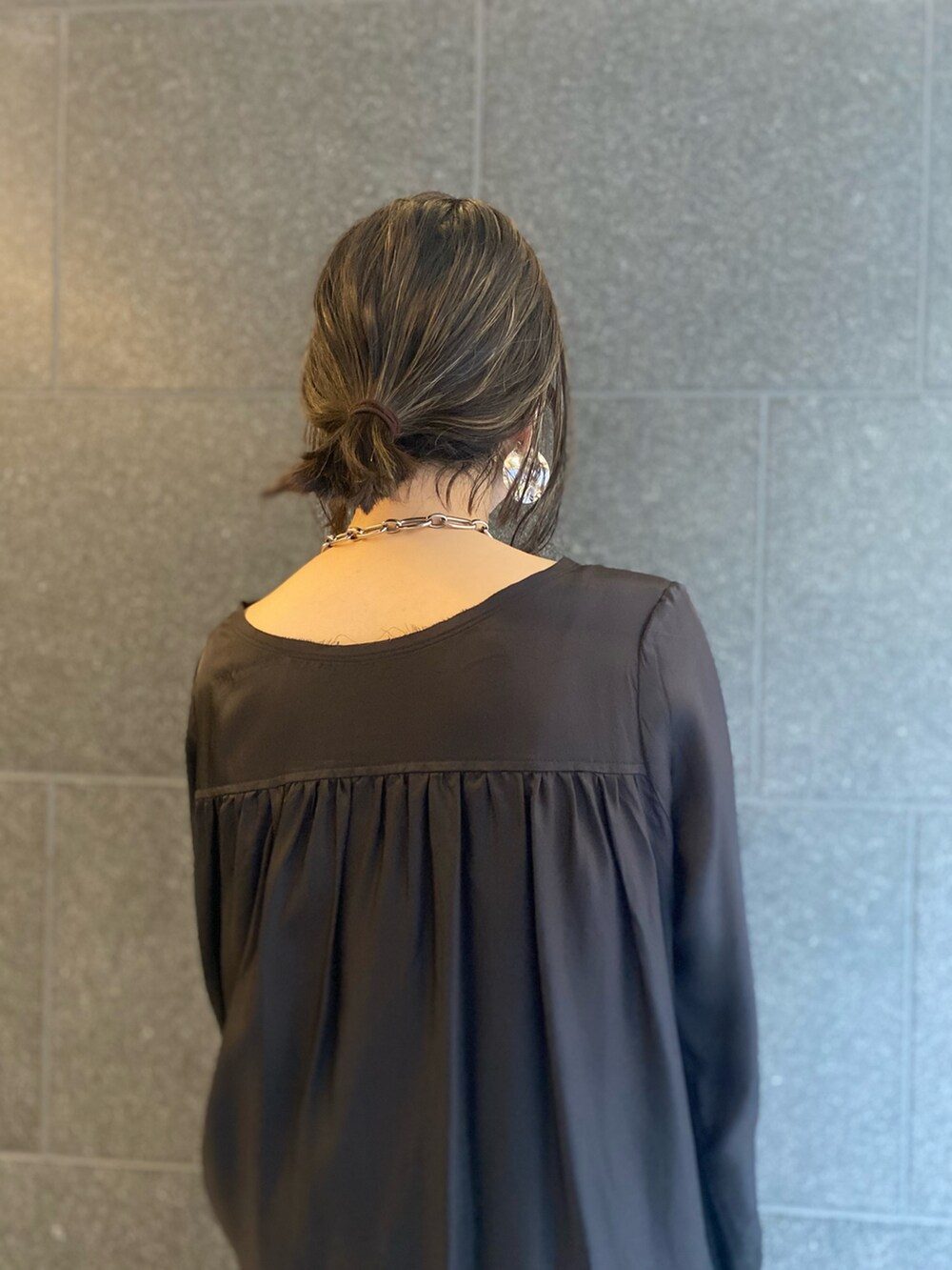 ホワイト系のショルダーバッグ、ブラック系のワンピース、シルバー系のネックレスを着用したレディースの春コーディネートの4枚目の写真