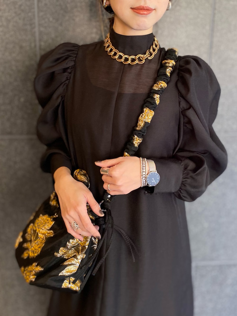 ブラック系のブーツ、ブラック系のワンピース、ブラック系のバッグを着用したレディースの春コーディネートの5枚目の写真