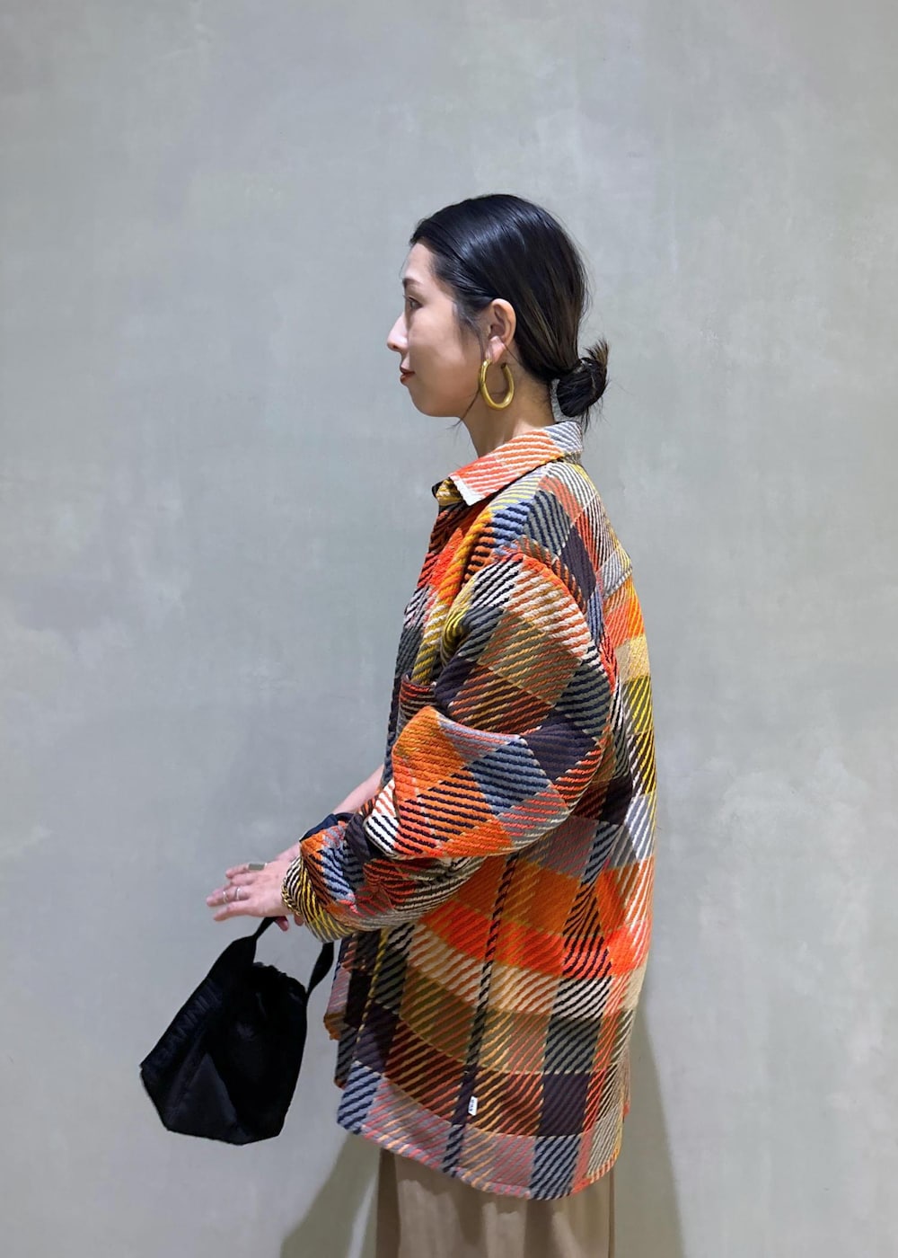 ブラック系のハンドバッグ、グリーン系のスラックスを着用したレディースの秋コーディネートの9枚目の写真