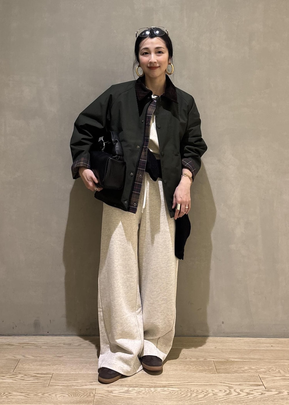 ブラック系のハンドバッグ、グリーン系のその他アウター、ホワイト系のその他パンツを着用したレディースの冬コーディネートの8枚目の写真