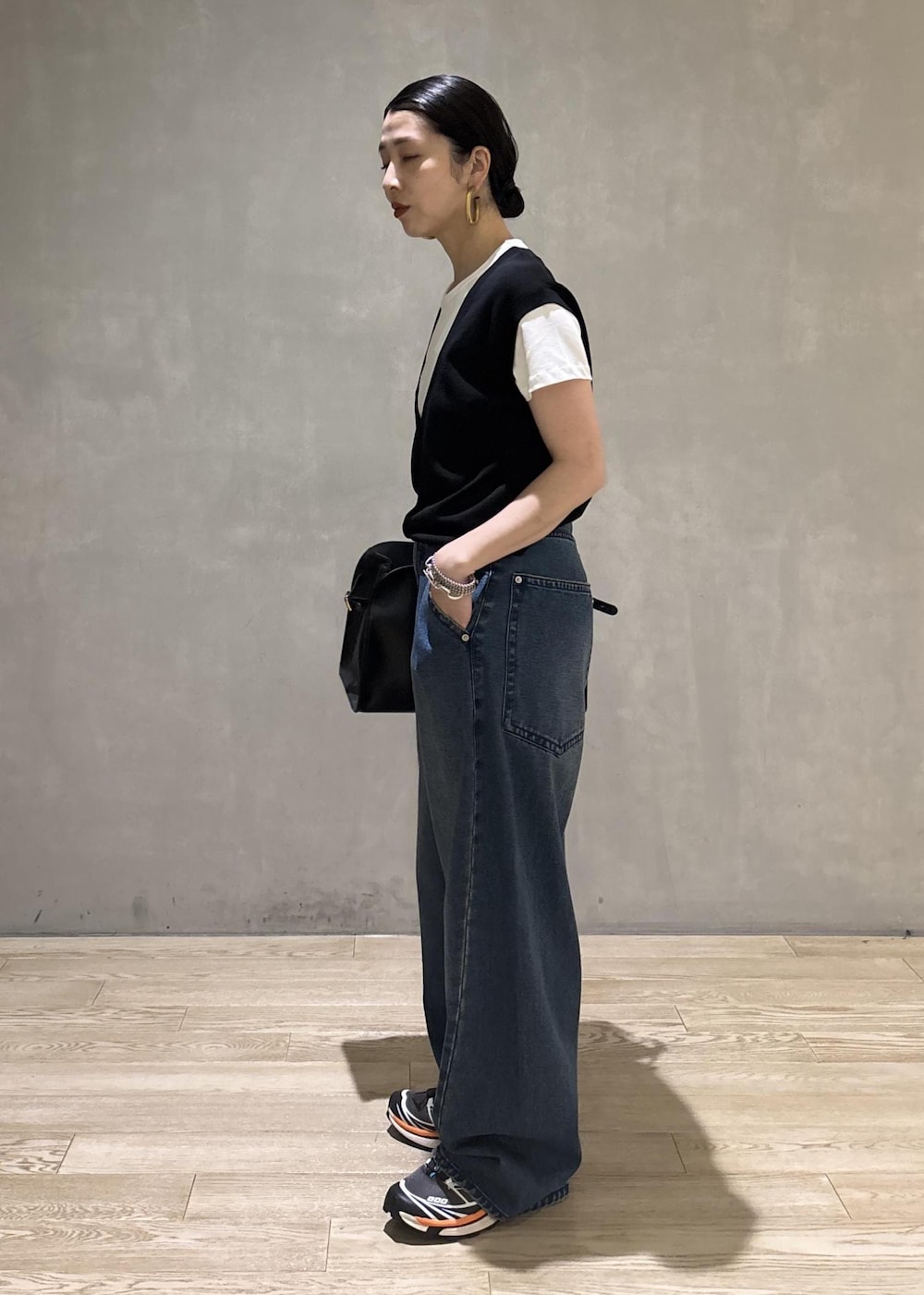 ブラック系のトートバッグ、ブラック系のTシャツ/カットソー、ブルー系のデニムパンツを着用したレディースの夏コーディネートの7枚目の写真
