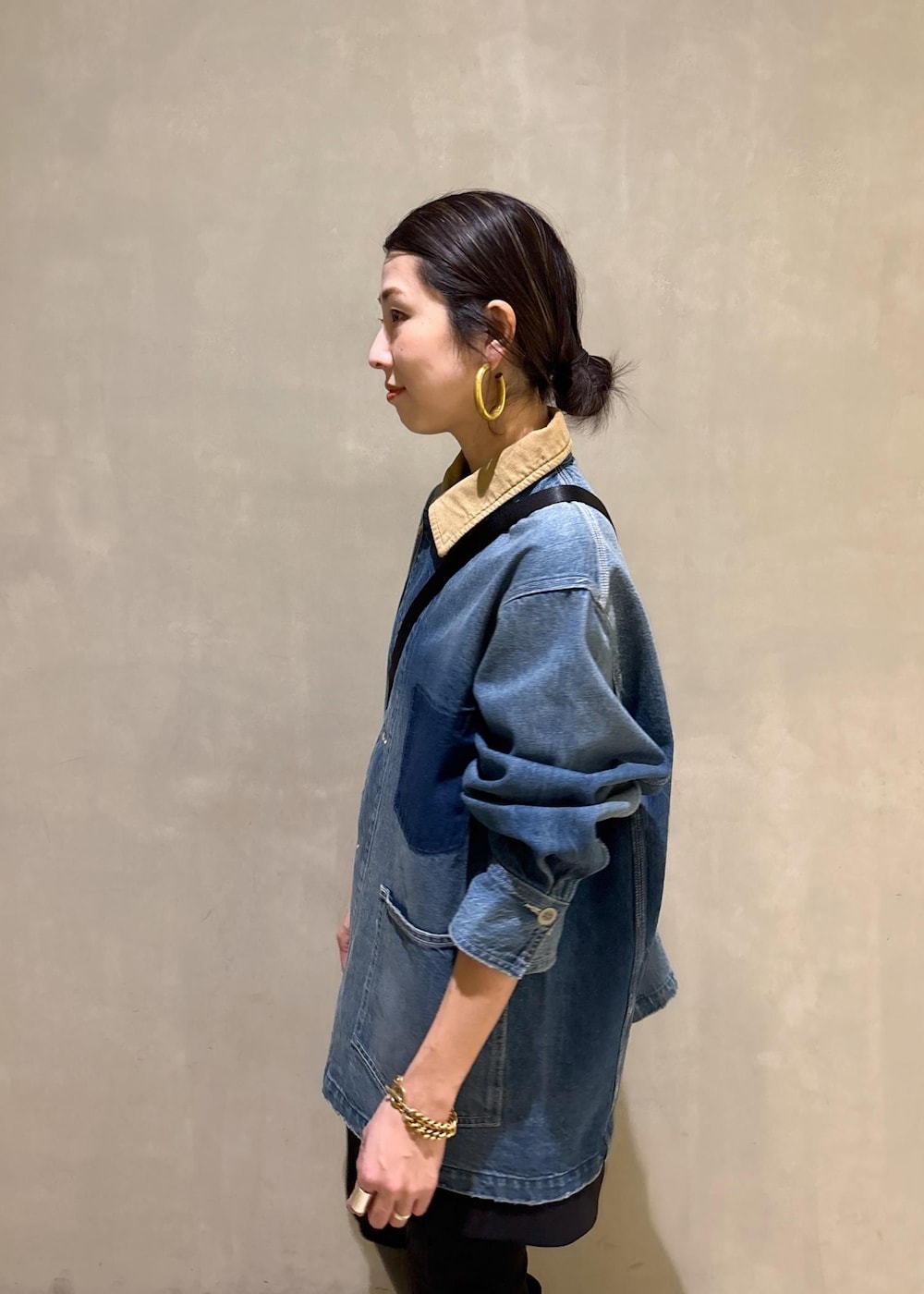 ベージュ系のトートバッグ、ブラック系のブーツ、ブラック系のスカートを着用したレディースの冬コーディネートの7枚目の写真