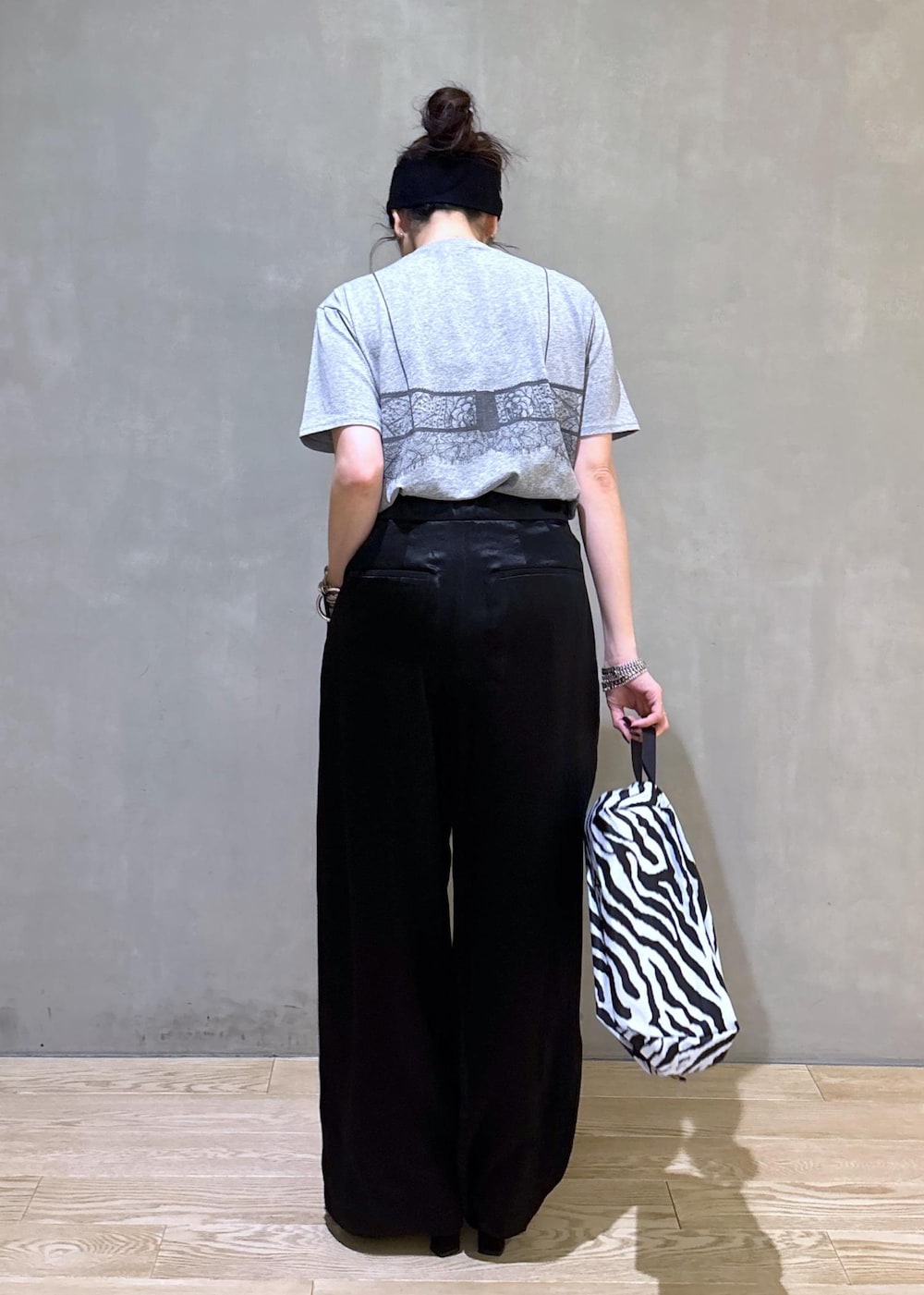 グレー系のTシャツ/カットソー、ブラック系のスラックス、ホワイト系のネックレスを着用したレディースの夏コーディネートの4枚目の写真