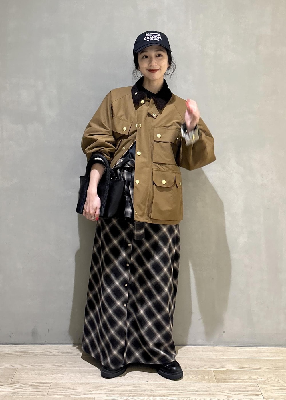 イエロー系のブルゾン、ブラック系のキャップを着用したレディースの秋コーディネートの6枚目の写真