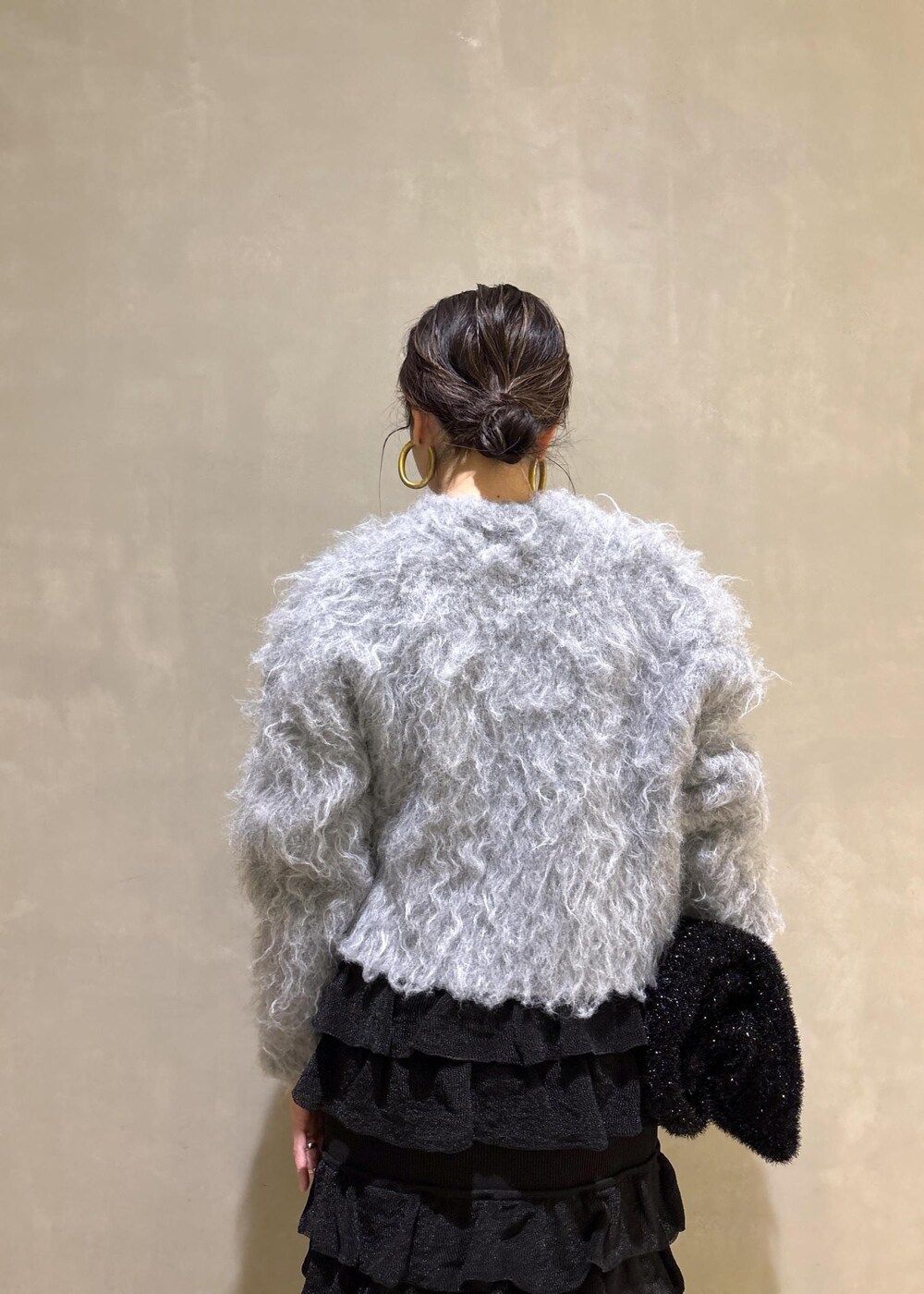 ブラック系のスカート、グレー系のカーディガン/ボレロ、ブラック系のトートバッグを着用したレディースの冬コーディネートの9枚目の写真