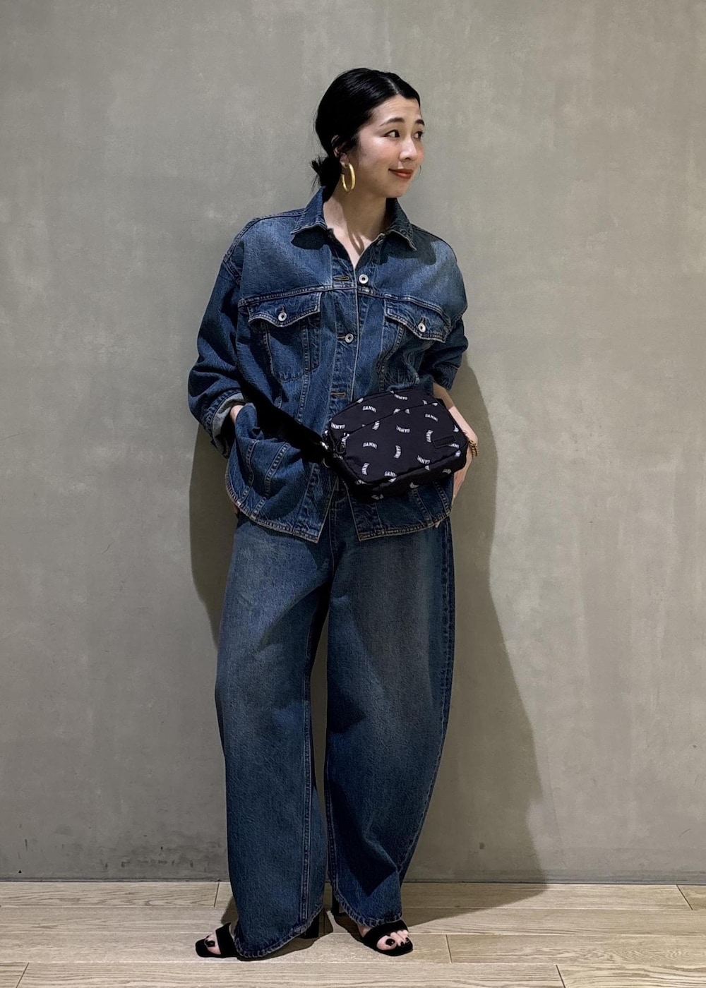 ブルー系のデニムジャケット、ブルー系のデニムパンツ、ブラック系のトートバッグを着用したレディースの春コーディネートの2枚目の写真