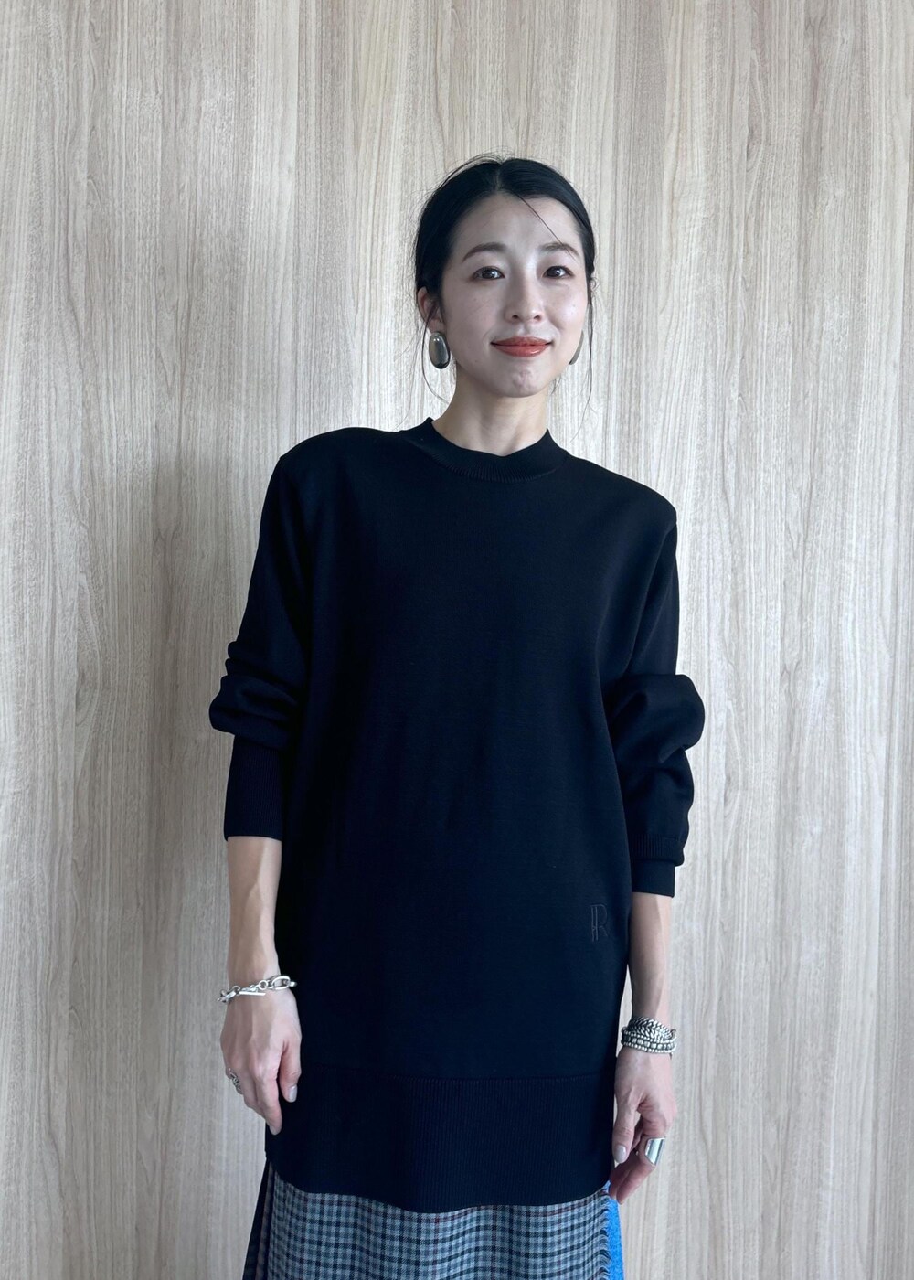 グレー系のスカート、ブラック系のブーツ、ブラック系のニット/セーターを着用したレディースの秋コーディネートの8枚目の写真