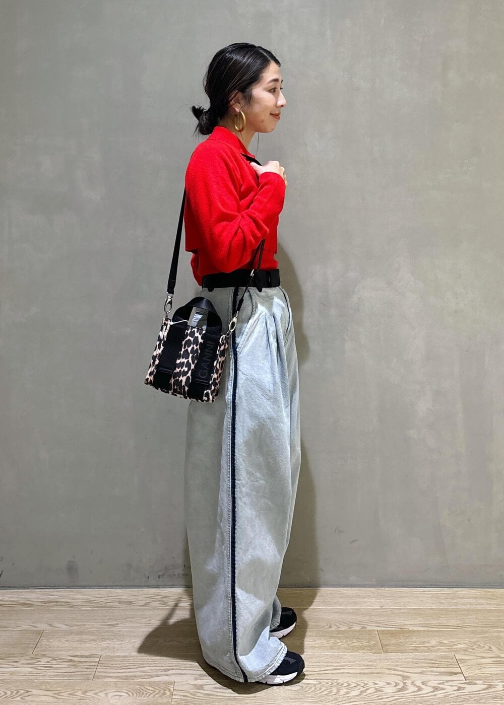 ベージュ系のトートバッグ、ブルー系のその他パンツ、レッド系のカーディガン/ボレロを着用したレディースの秋コーディネートの3枚目の写真