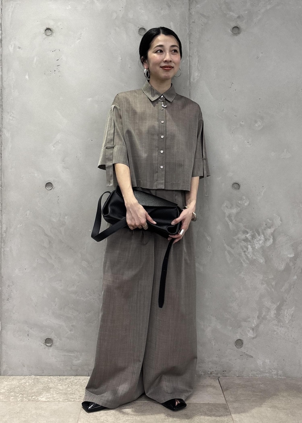 ブラック系のサンダル、ベージュ系のシャツ/ブラウス、ベージュ系のスラックスを着用したレディースの春コーディネートの2枚目の写真