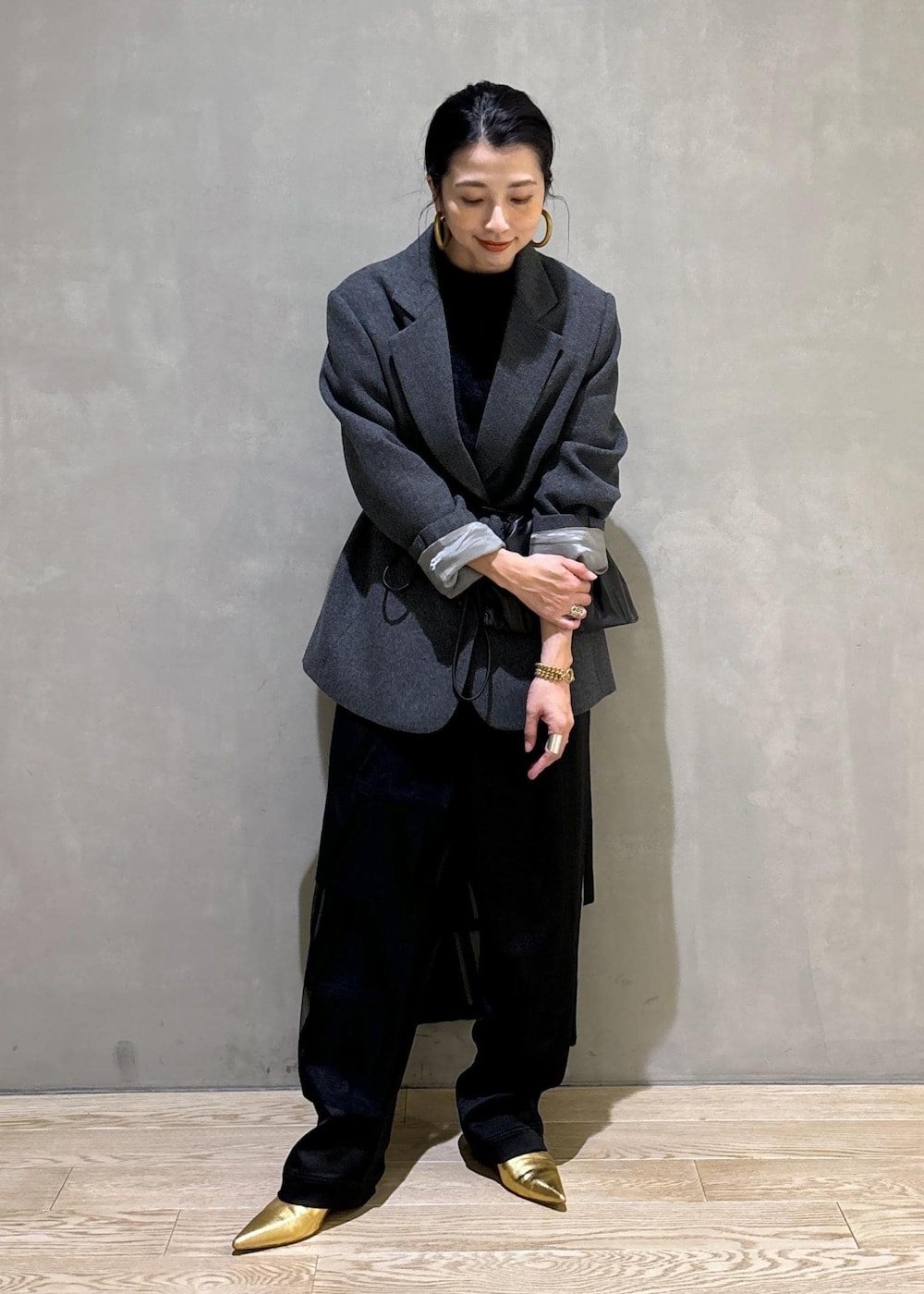 グレー系のニット/セーター、グレー系のテーラードジャケット、ブラック系のその他パンツを着用したレディースの秋コーディネートの10枚目の写真
