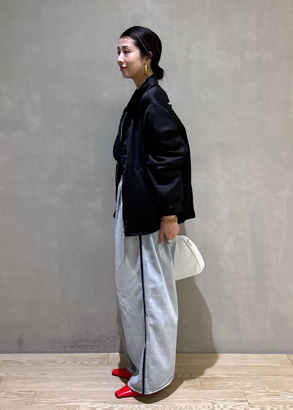 ブラック系のニット/セーター、ホワイト系のボストンバッグ、ブルー系のその他パンツを着用したレディースの冬コーディネートの6枚目の写真