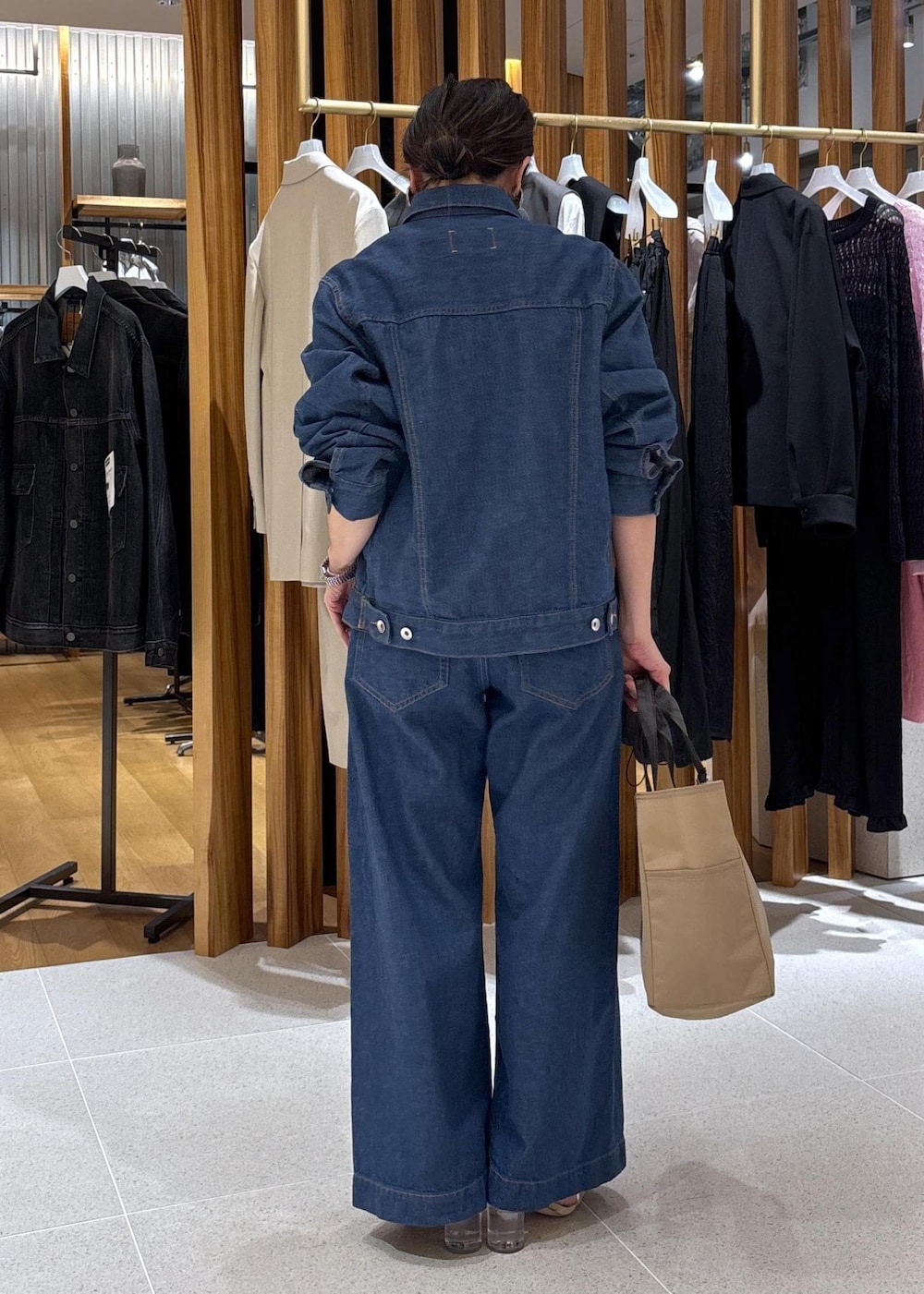 ベージュ系のハンドバッグ、ブルー系のTシャツ/カットソー、ブルー系のブルゾンを着用したレディースの冬コーディネートの5枚目の写真