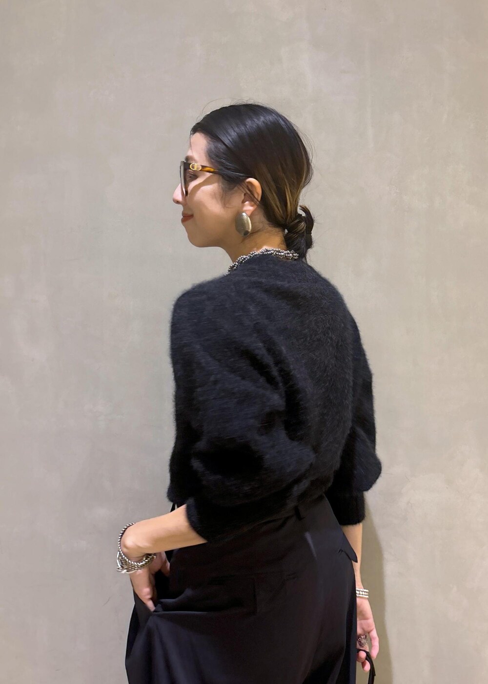 ホワイト系のパンプス、ブラック系のスラックス、グレー系のニット/セーターを着用したレディースの秋コーディネートの10枚目の写真