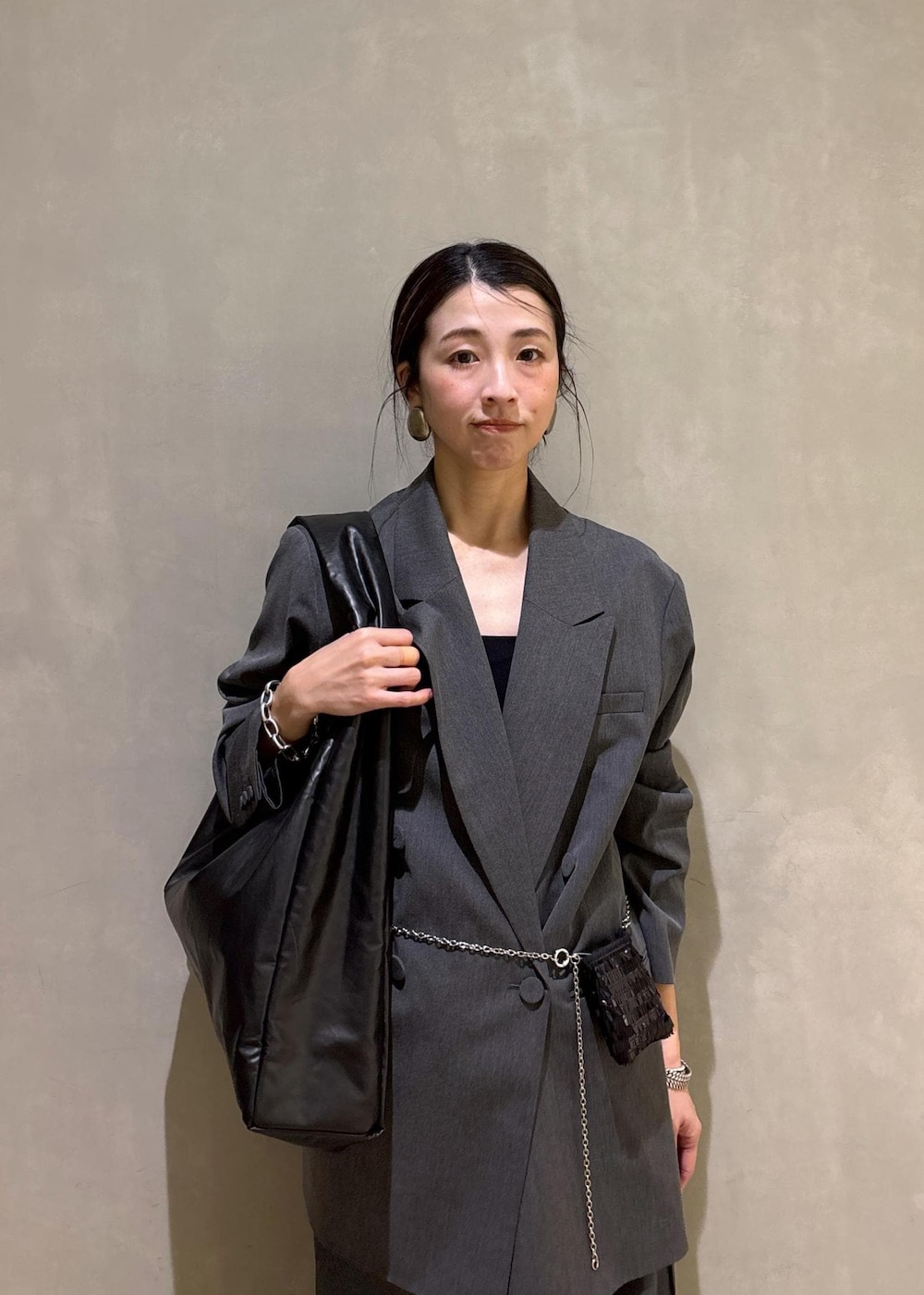 ブラック系のショルダーバッグ、グレー系のその他パンツ、グレー系のテーラードジャケットを着用したレディースの冬コーディネートの7枚目の写真