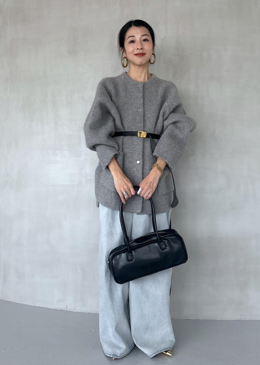 ゴールド系のパンプス、ブルー系のその他パンツ、ブラック系のボストンバッグを着用したレディースの秋コーディネートの8枚目の写真