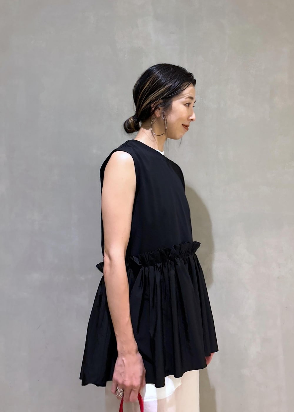 ホワイト系のタンクトップ、ホワイト系のその他パンツ、レッド系のハンドバッグを着用したレディースの夏コーディネートの9枚目の写真