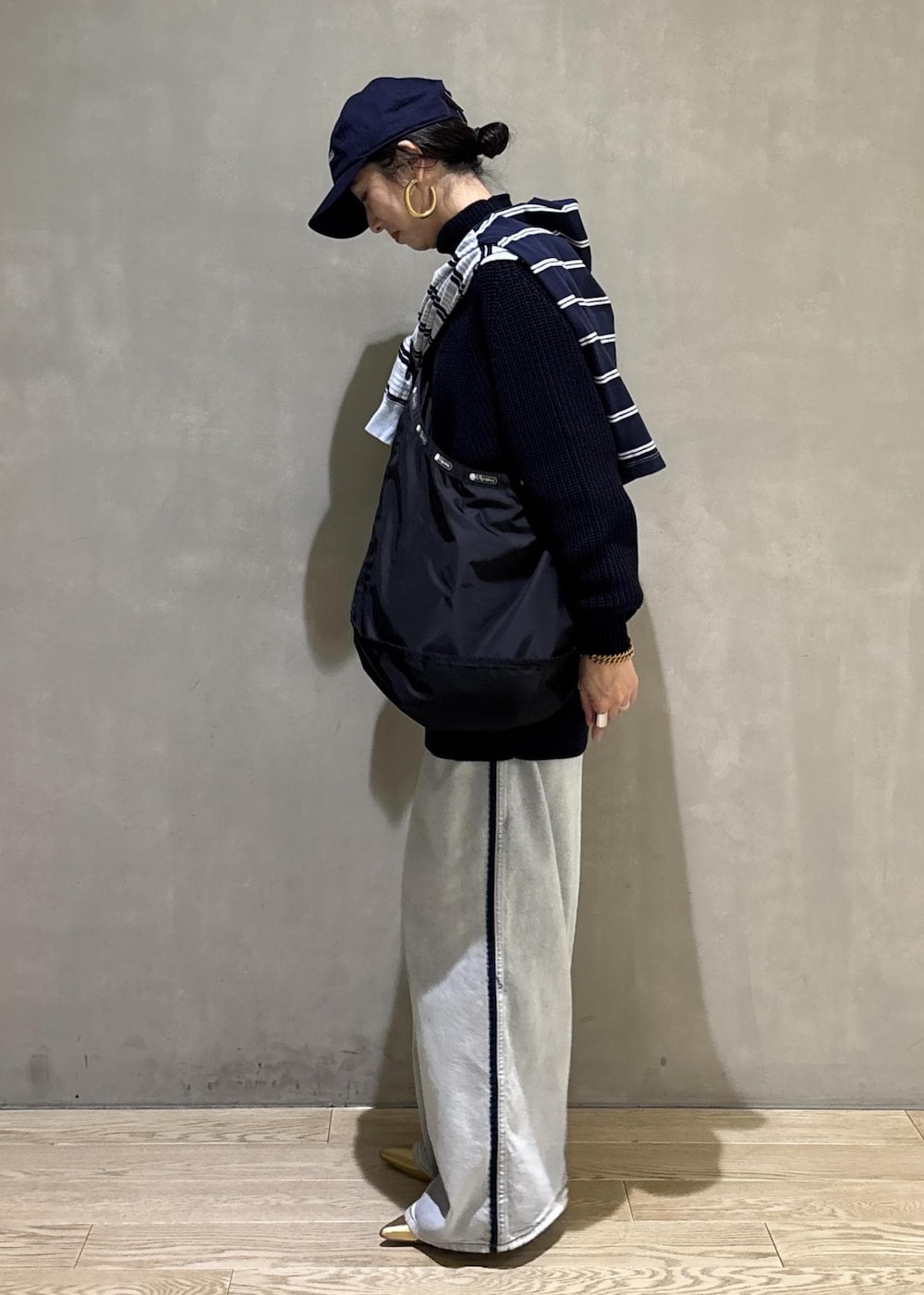 ブルー系のデニムパンツ、ブラック系のショルダーバッグを着用したレディースの秋コーディネートの3枚目の写真