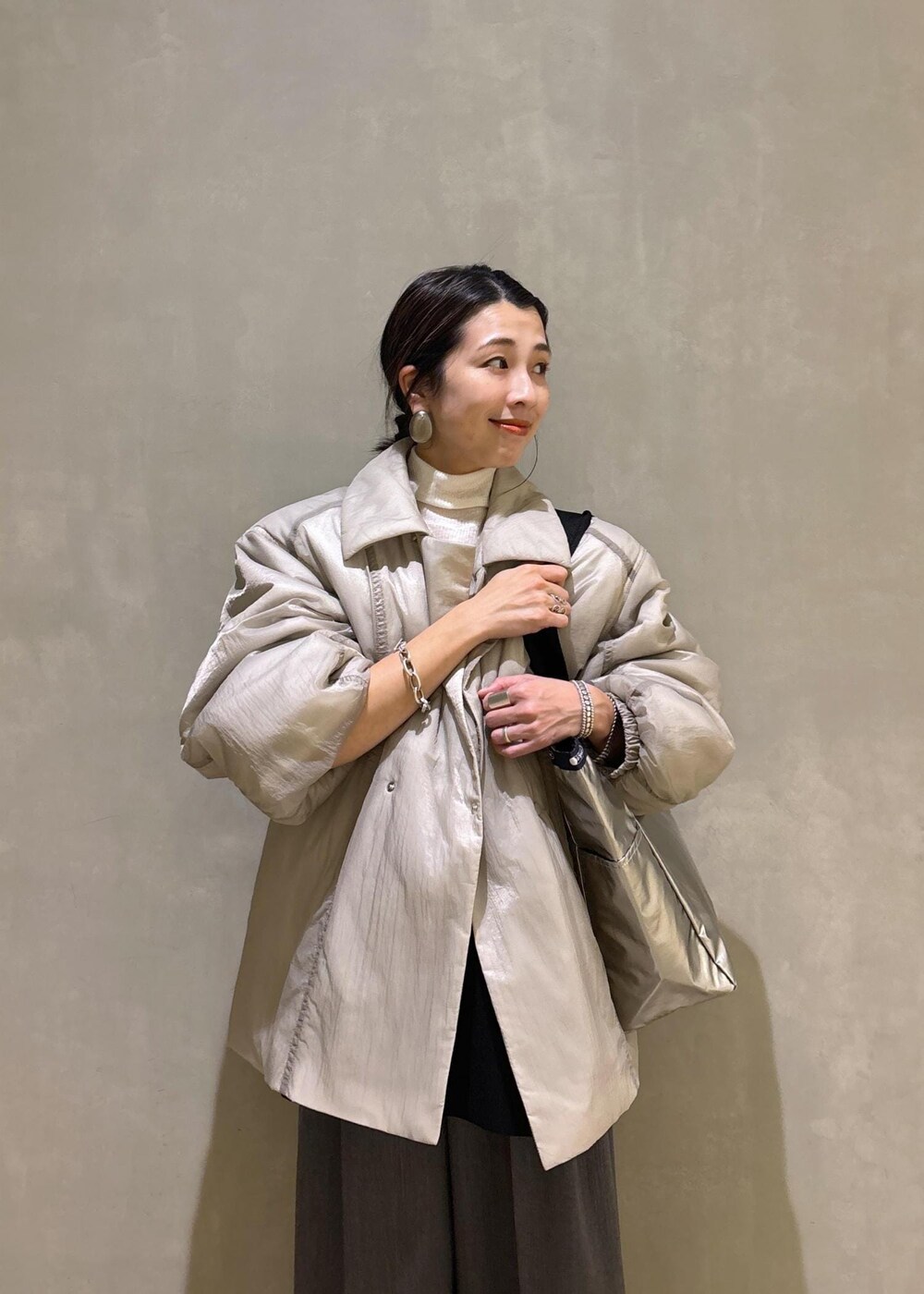 グレー系のスニーカー、ブラック系のシャツ/ブラウス、ベージュ系のブルゾンを着用したレディースの秋コーディネートの7枚目の写真