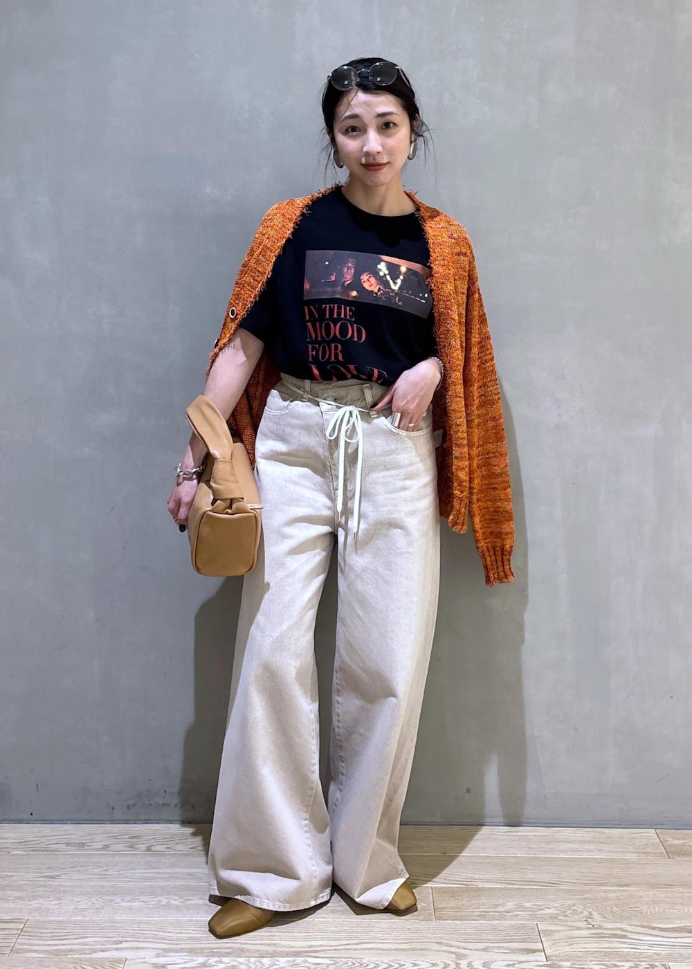 ベージュ系のハンドバッグ、ホワイト系のデニムパンツ、ホワイト系のTシャツ/カットソーを着用したレディースの春コーディネートの7枚目の写真