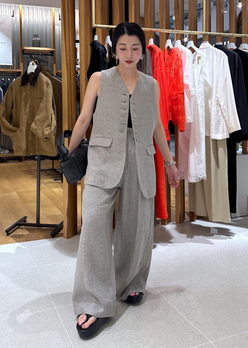 ブラック系のハンドバッグ、ベージュ系のその他パンツ、ベージュ系のベストを着用したレディースの春コーディネートの5枚目の写真