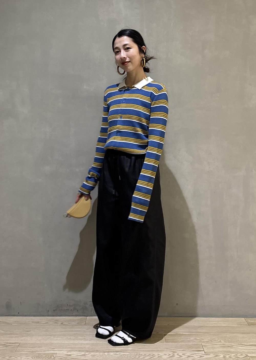 ブルー系のポロシャツ、ブラック系のその他パンツ、イエロー系のキーホルダーを着用したレディースの秋コーディネートの6枚目の写真