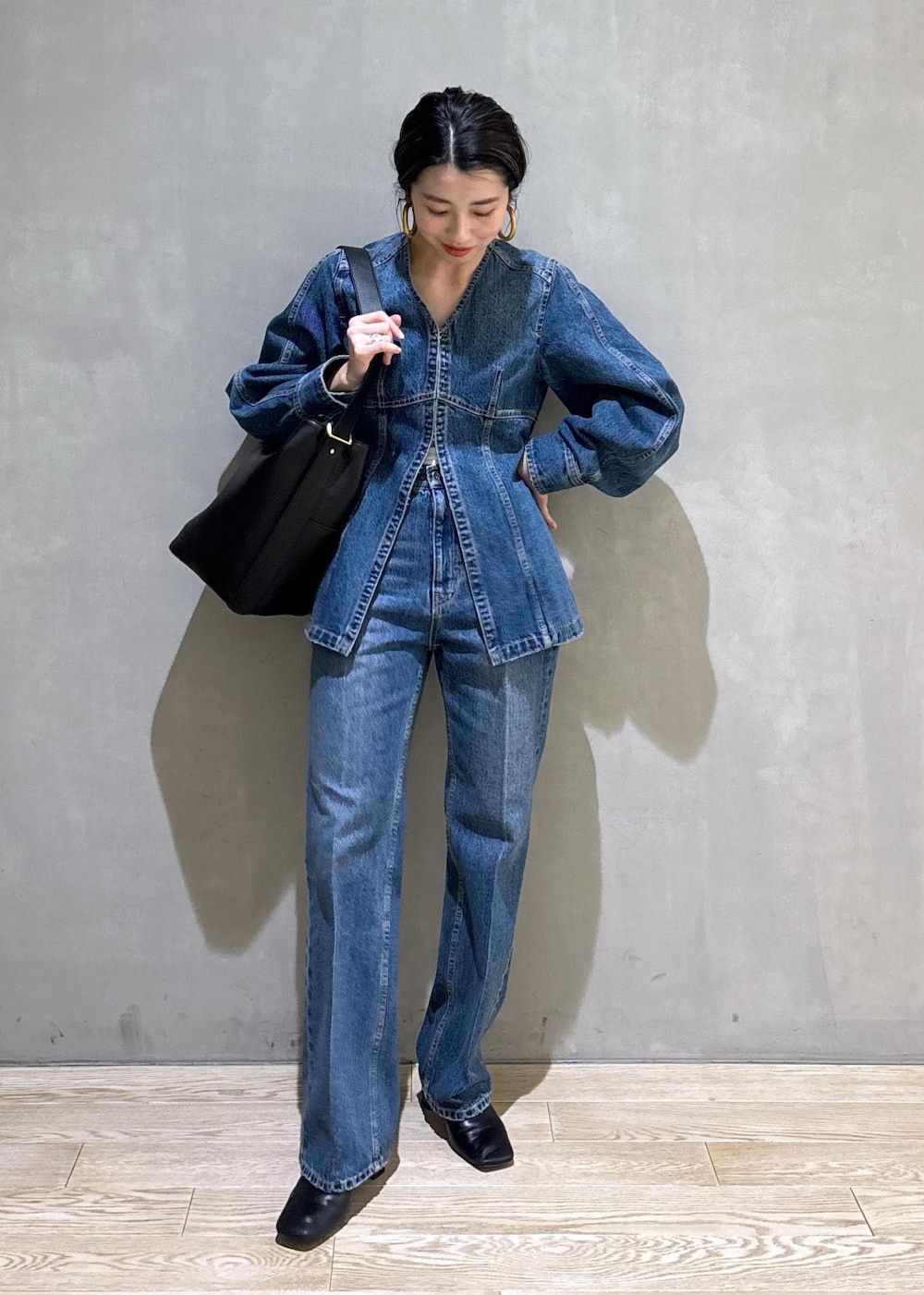 ブルー系のシャツ/ブラウス、ブルー系のデニムパンツ、ブラック系のショルダーバッグを着用したレディースの冬コーディネートの2枚目の写真