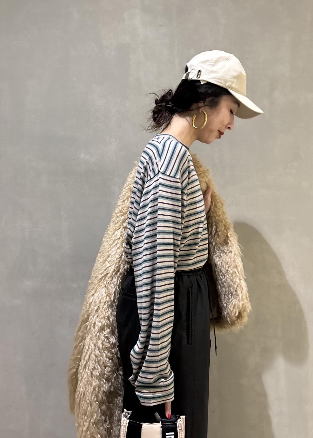 ベージュ系のトートバッグ、ベージュ系のその他アウター、ブラック系のその他パンツを着用したレディースの秋コーディネートの8枚目の写真