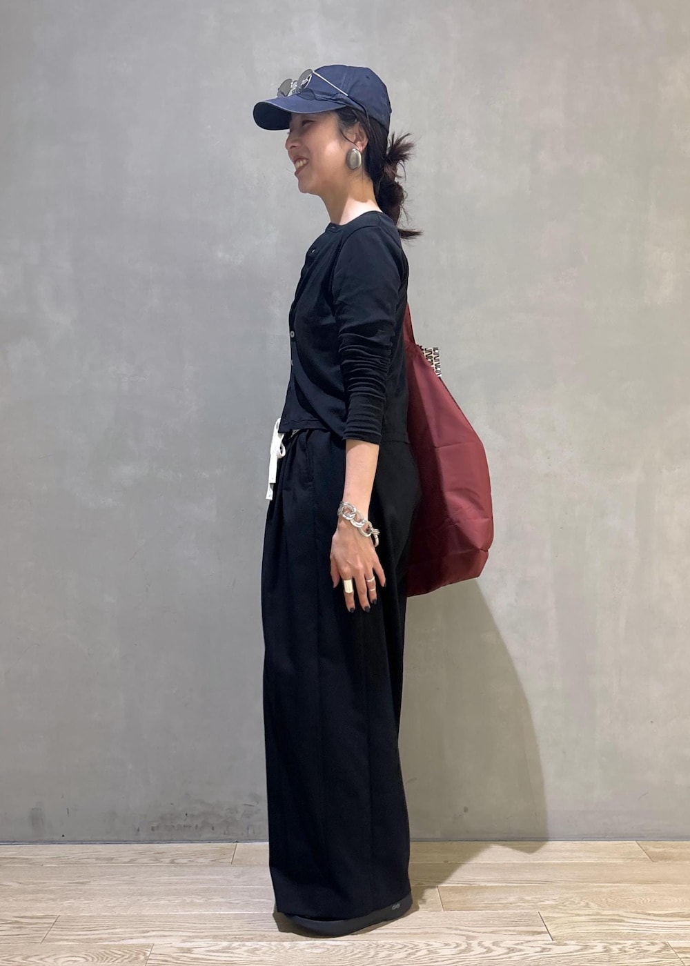 ブラック系のカーディガン/ボレロ、ブラック系のスラックス、シルバー系のサングラスを着用したレディースの夏コーディネートの5枚目の写真