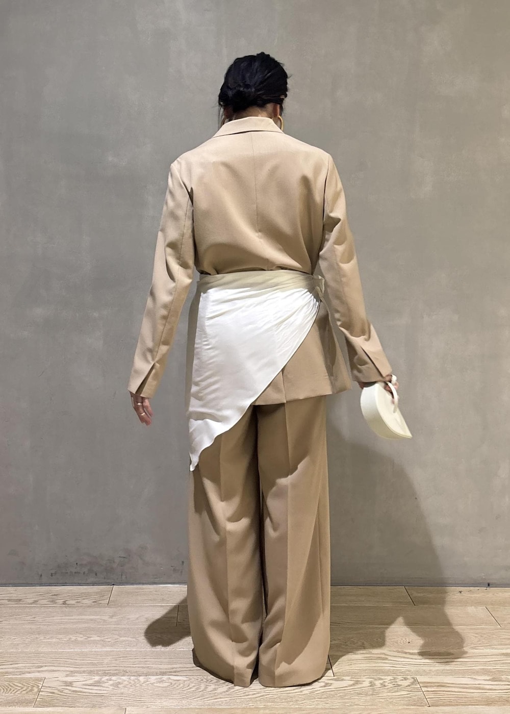 ベージュ系のテーラードジャケット、ホワイト系のシャツ/ブラウス、ベージュ系のスラックスを着用したレディースの冬コーディネートの3枚目の写真