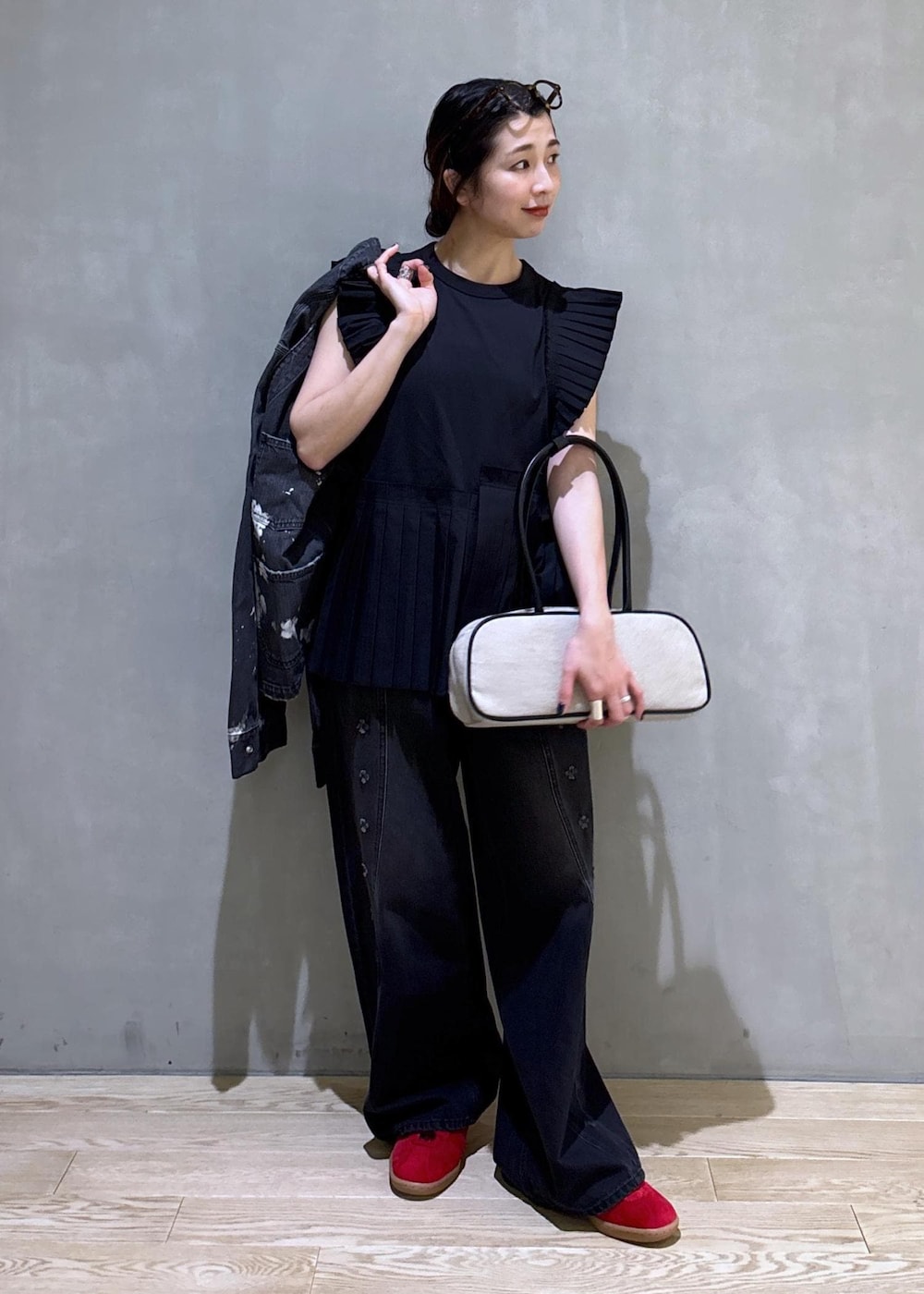 ブラック系のTシャツ/カットソー、ブラック系のデニムパンツ、ホワイト系のボストンバッグを着用したレディースの春コーディネートの6枚目の写真