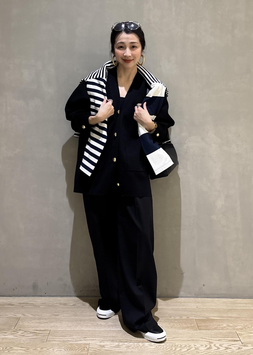 ブルー系のTシャツ/カットソー、ブラック系のカーディガン/ボレロ、ブラック系のスラックスを着用したレディースの冬コーディネートの2枚目の写真