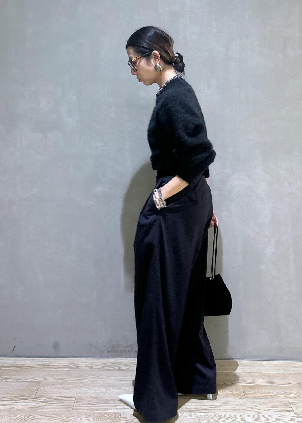 ホワイト系のパンプス、ブラック系のスラックス、グレー系のニット/セーターを着用したレディースの秋コーディネートの5枚目の写真