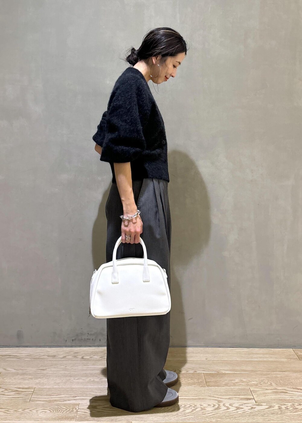 ホワイト系のボストンバッグ、グレー系のカーディガン/ボレロ、ブルー系のスニーカーを着用したレディースの秋コーディネートの3枚目の写真