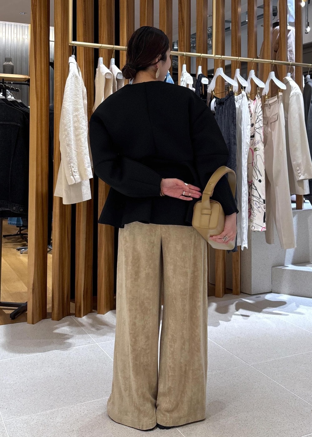 ベージュ系のハンドバッグ、ブラック系のローファー、ブラック系のカーディガン/ボレロを着用したレディースの冬コーディネートの4枚目の写真