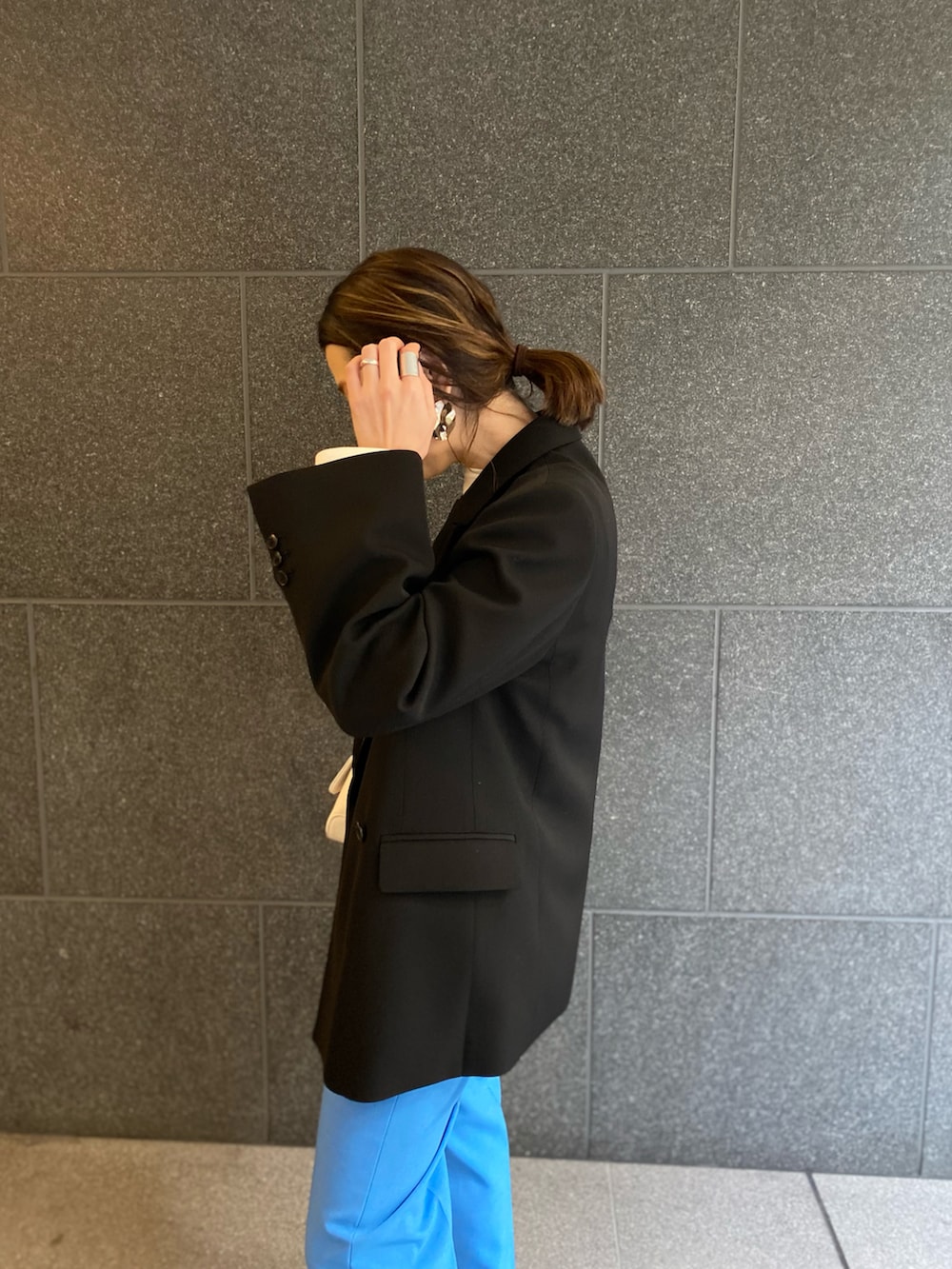 ブルー系のスラックス、シルバー系のバレエシューズ、ブラック系のテーラードジャケットを着用したレディースの春コーディネートの2枚目の写真