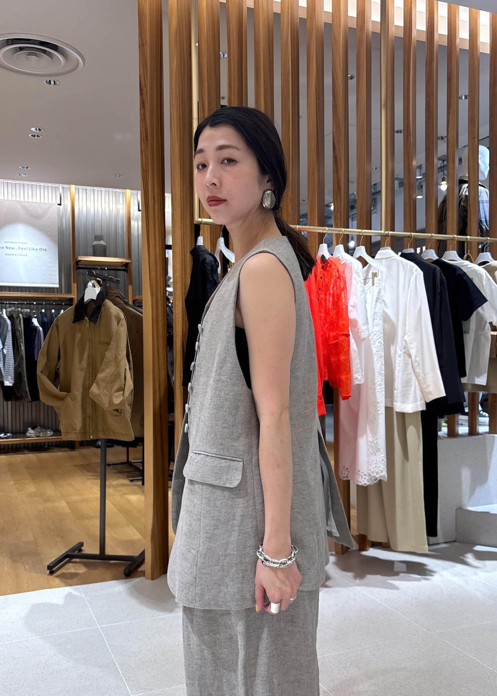 ブラック系のハンドバッグ、ベージュ系のその他パンツ、ベージュ系のベストを着用したレディースの春コーディネートの6枚目の写真