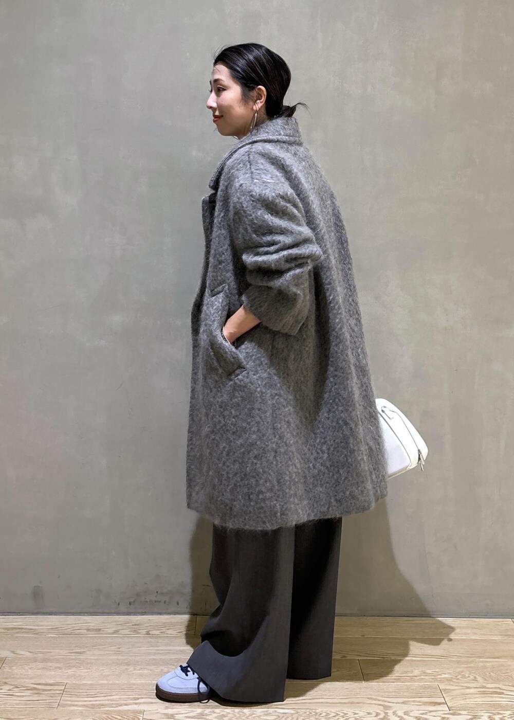 ホワイト系のボストンバッグ、グレー系のカーディガン/ボレロ、グレー系のチェスターコートを着用したレディースの秋コーディネートの3枚目の写真