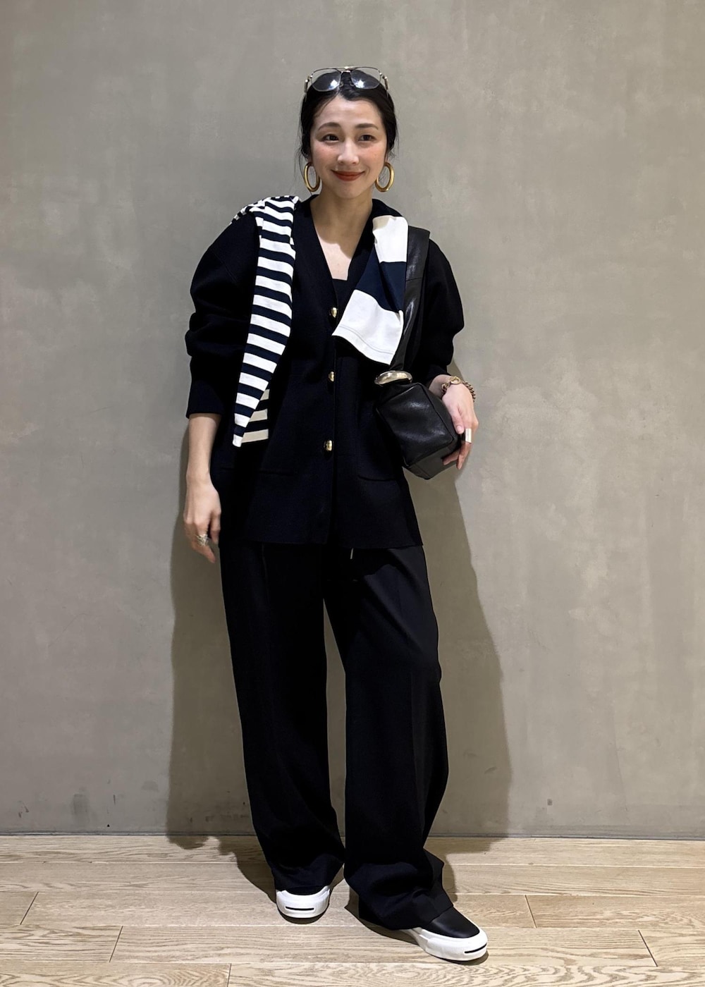 ブルー系のTシャツ/カットソー、ブラック系のカーディガン/ボレロ、ブラック系のスラックスを着用したレディースの冬コーディネートの4枚目の写真