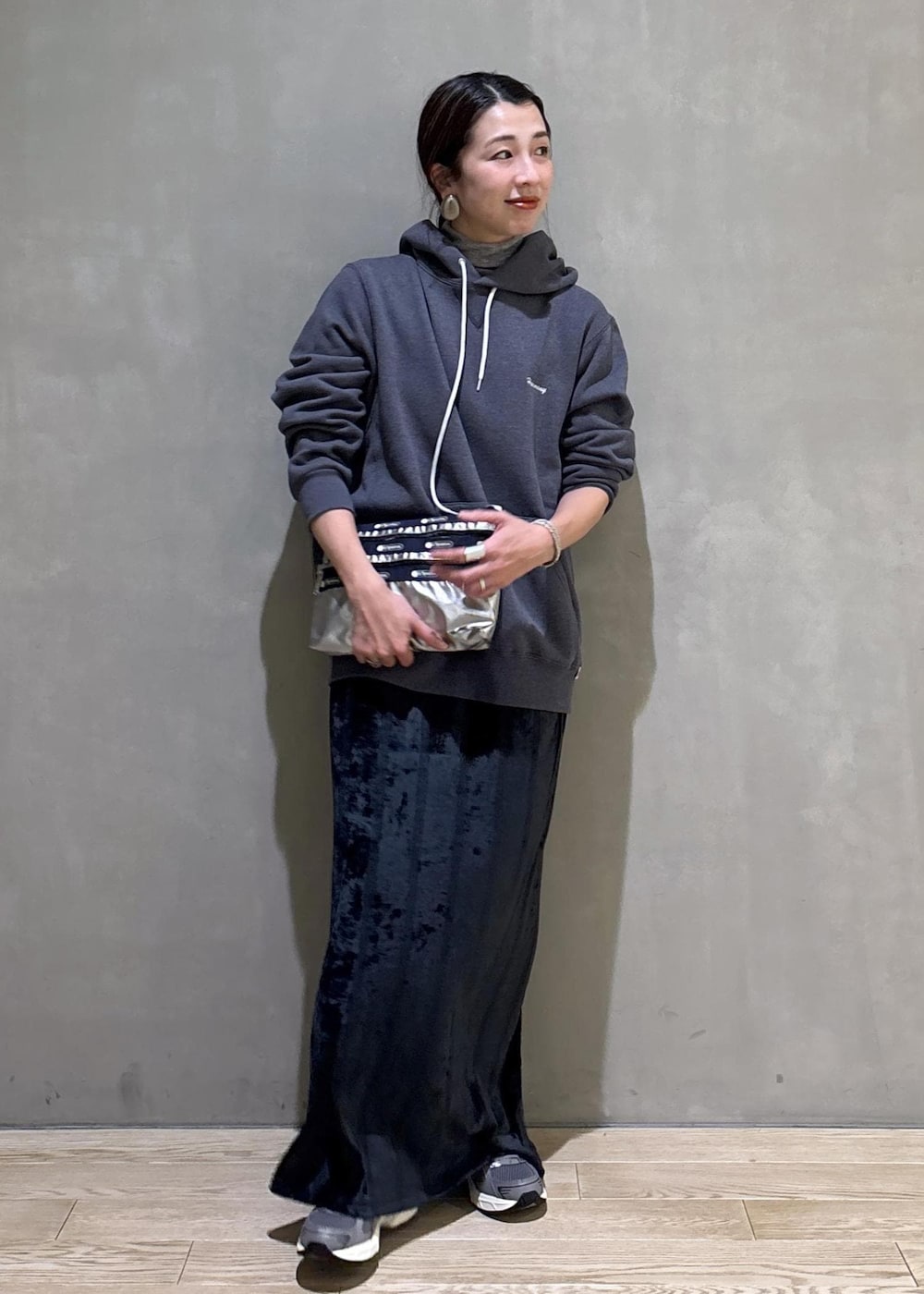 グレー系のスニーカー、ブラック系のスカート、グレー系のパーカーを着用したレディースの冬コーディネートの6枚目の写真