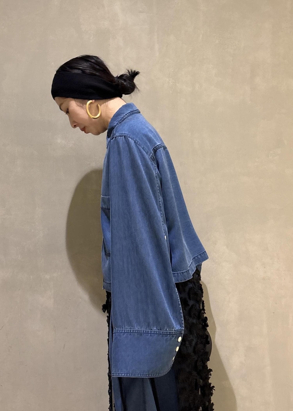 ブルー系のシャツ/ブラウス、ブルー系のデニムパンツ、ブラック系のクラッチバッグを着用したレディースの冬コーディネートの9枚目の写真