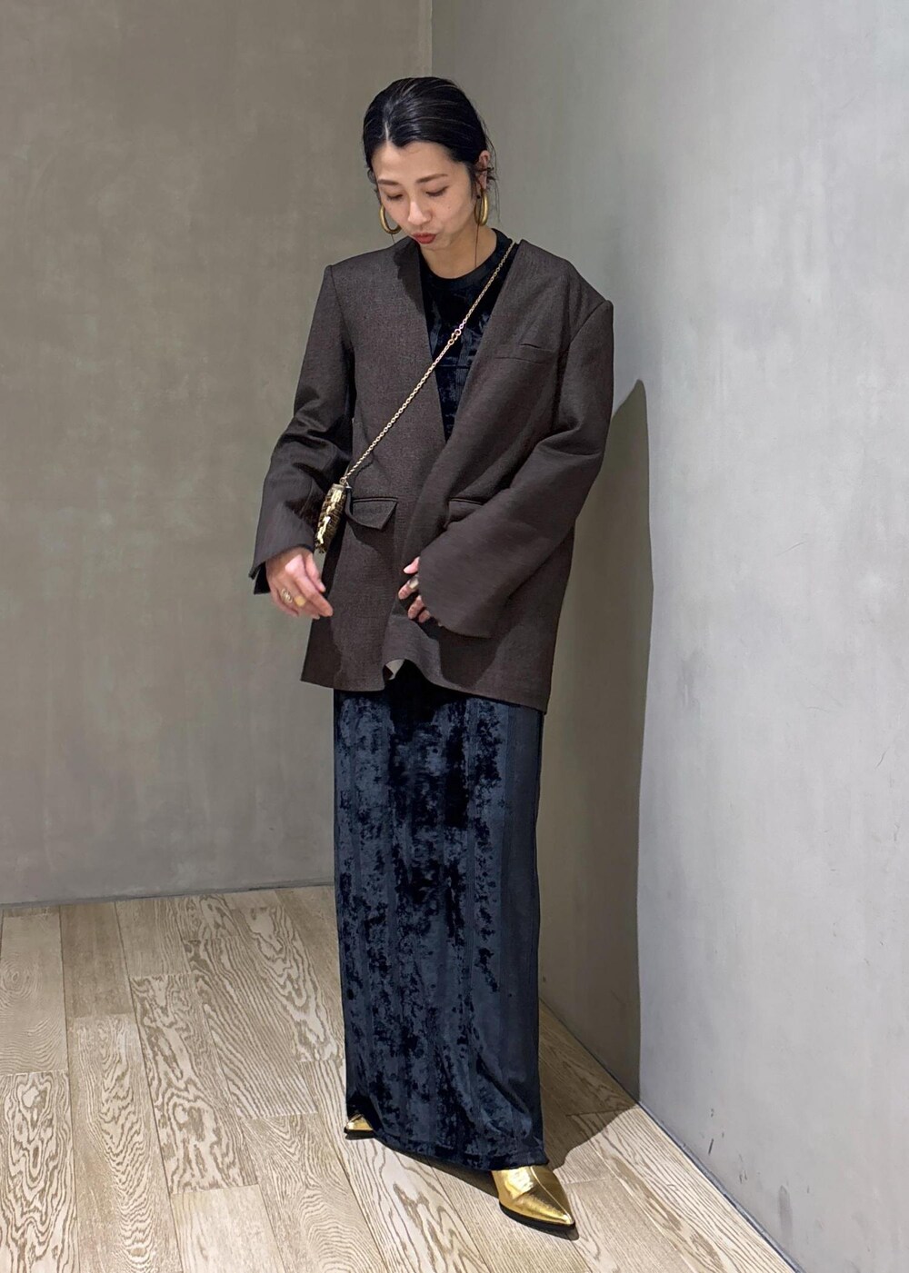 ブラック系のスカート、ブラック系のTシャツ/カットソー、ゴールド系のブーツを着用したレディースの冬コーディネートの3枚目の写真