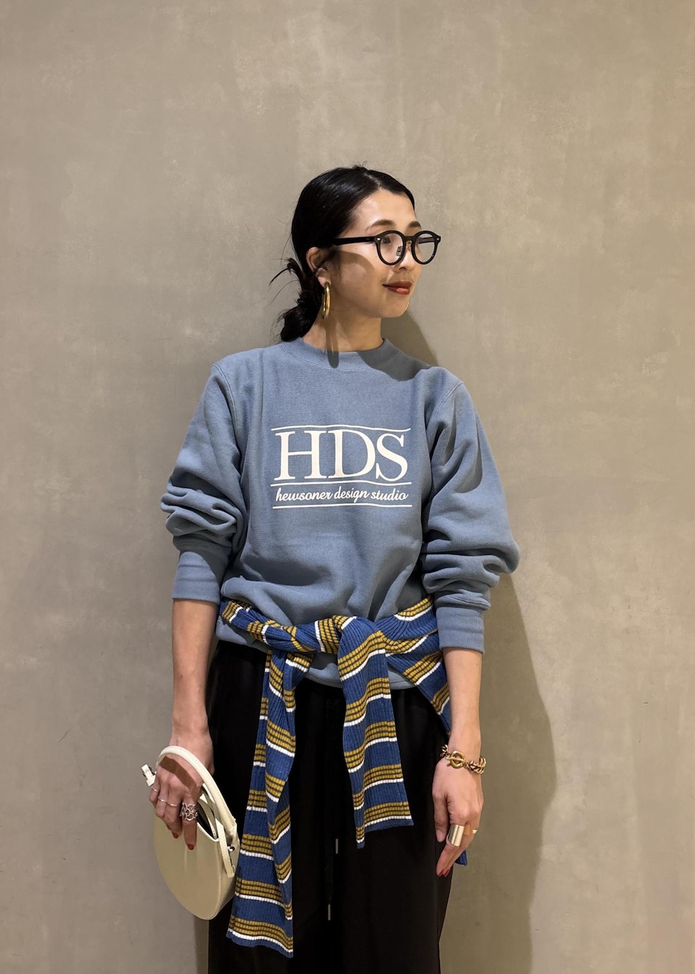 ホワイト系のハンドバッグ、ブルー系のスウェット、ブルー系のポロシャツを着用したレディースの秋コーディネートの9枚目の写真