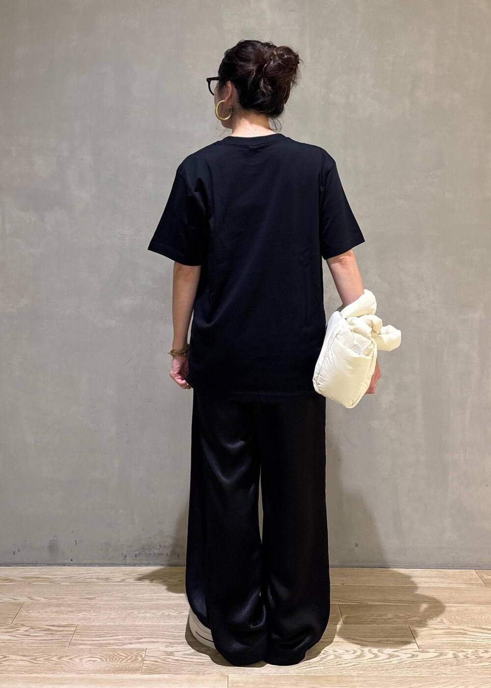 ブラック系のスラックス、イエロー系のTシャツ/カットソーを着用したレディースの夏コーディネートの3枚目の写真