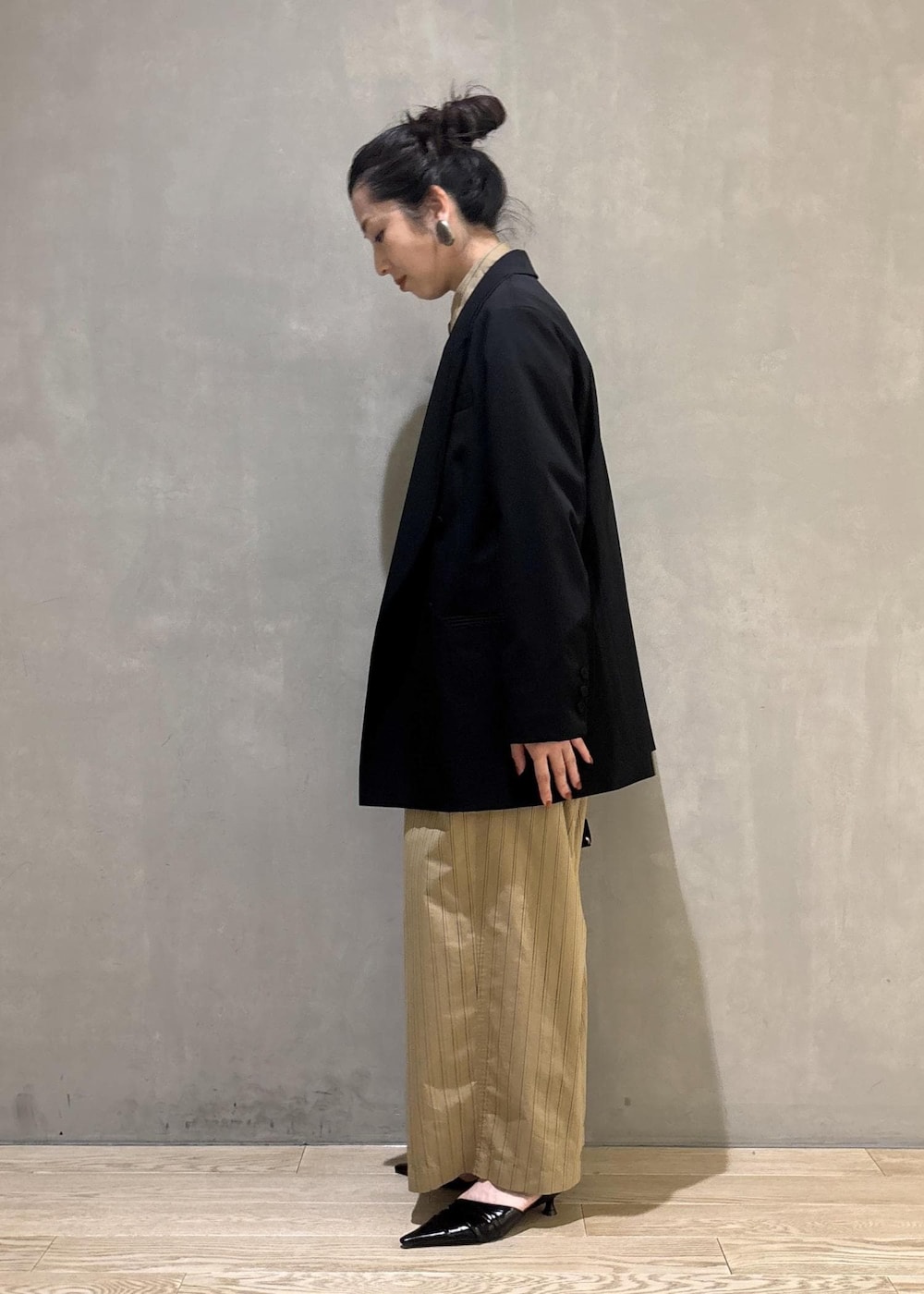 ベージュ系のショルダーバッグ、ベージュ系のスラックス、ベージュ系のシャツ/ブラウスを着用したレディースの秋コーディネートの2枚目の写真