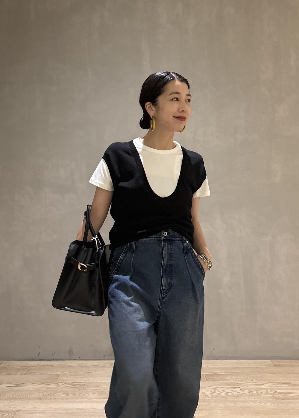 ブラック系のトートバッグ、ブラック系のTシャツ/カットソー、ブルー系のデニムパンツを着用したレディースの夏コーディネートの8枚目の写真